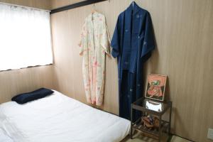 a bedroom with a bed and a robe hanging on a wall at Housegreen201 in Tokyo