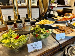 a buffet with bowls of salad and bottles of wine at Henn na Hotel Kyoto Hachijoguchi in Kyoto