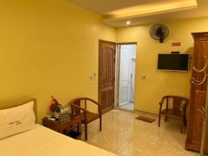 - une chambre avec un lit et une télévision murale dans l'établissement Thien Son Guesthouse, à Ha Giang
