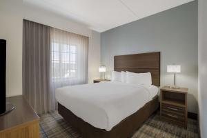 um quarto de hotel com uma cama grande e uma janela em MainStay Suites Wilmington em Wilmington