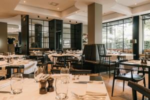 Serwir Hotel في سينت-نيكلاس: مطعم بطاولات وكراسي ونوافذ