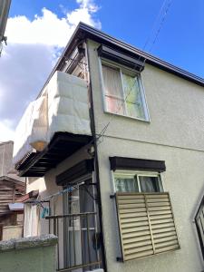 un edificio con una puerta y ventanas. en Housegreen201, en Tokio