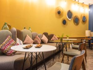 Ibis Abdelmoumen Casa Centre في الدار البيضاء: غرفة انتظار مع أريكة وطاولات وكراسي