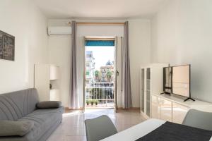 ein weißes Wohnzimmer mit einem Sofa und einem Fenster in der Unterkunft Riva Serena in Lido di Ostia