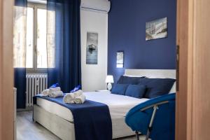 ein Schlafzimmer mit blauen Wänden und ein Bett mit Handtüchern drauf in der Unterkunft Riva Serena in Lido di Ostia
