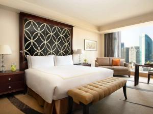 a hotel room with a large bed and a couch at Fairmont Beijing in Beijing