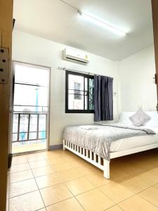 Schlafzimmer mit einem Bett und einem Fenster in der Unterkunft Dragon XIV in Bangkok