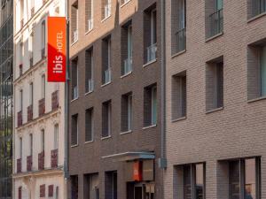 a brick building with a red sign in front of it at Ibis Paris Gare Montparnasse Catalogne in Paris