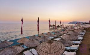 a row of beach chairs with umbrellas on the beach at Club Hotel Anjeliq in Alanya