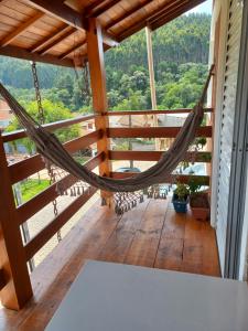 a hammock on the porch of a house at casa de temporada do Braz in Monte Verde