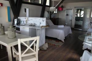 a room with a bed and a table and a kitchen at Bungalows de La Casona del Lago in Serranillos Playa