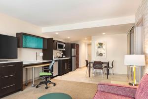 cocina y sala de estar con escritorio y sillas en Home2 Suites By Hilton Milwaukee West, en West Allis