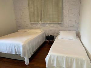 two beds sitting next to each other in a bedroom at Casa com ótima localização in São Sebastião