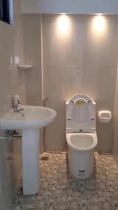 uma casa de banho com um WC branco e um lavatório. em The Veehive Guesthouse em Cebu