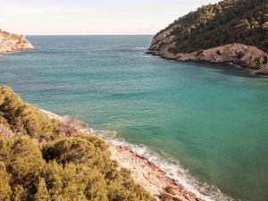 a view of the ocean from a cliff at Mondrian Ibiza in Cala Llonga