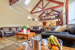 a living room with couches and a table at Barn in Sedbergh