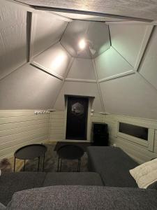 een kamer met 2 stoelen, een bed en een plafond bij Camp Caroli Hobbit Hut in Jukkasjärvi