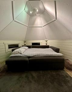 a bed in a room with a large ceiling at Camp Caroli Hobbit Hut in Jukkasjärvi