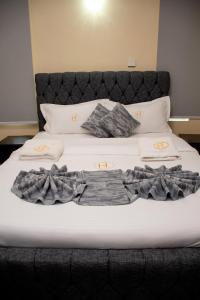 ein großes Bett mit weißen Laken und Kissen in der Unterkunft Thehaven254 in Nakuru