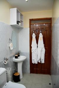 ein Badezimmer mit weißen Handtüchern, die an einer Tür hängen in der Unterkunft Thehaven254 in Nakuru + 51 Fotos