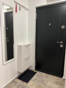 a bathroom with a black door and a mirror at Titan Studio in Bucharest