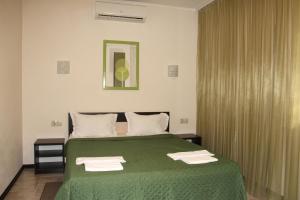 a bedroom with a green bed with two towels on it at Breeze Hotel in Odesa