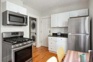a kitchen with a stove and a stainless steel refrigerator at East Cambridge 3br w wd nr cafes bars BOS-910 in Cambridge