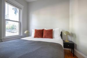 a bedroom with a bed with orange pillows and a window at East Cambridge 3br w wd nr cafes bars BOS-910 in Cambridge