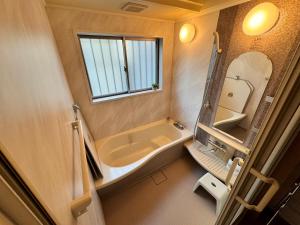 TENT OKAYAMA - 3 bedrooms, 10 min walk from Okayama Station في Hokancho: حمام صغير مع حوض ومرآة