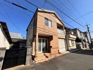 a brick house on the side of a street at TENT OKAYAMA - 3 bedrooms, 10 min walk from Okayama Station in Hokancho