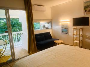 - une chambre avec un lit, un canapé et une fenêtre dans l'établissement Studio Fresh&Cosy Trois-Ilets - 3 étoiles-Hotel Carayou, à Les Trois-Îlets