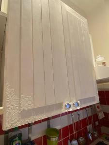 a white cabinet in a kitchen with at Casa Xenia in Trieste +4 photos