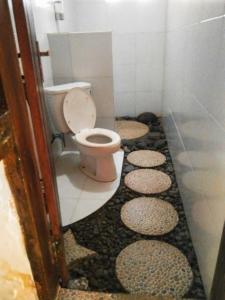 uma casa de banho com WC e pedras no chão em Gubuk Baru Homestay em Tetebatu