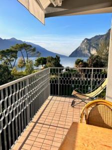 a balcony with a table and chairs and a view of the water at Holiday Apartments Bellariva in Riva del Garda