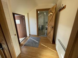 a hallway with a door leading to a bathroom at The Shippon stunning views! in Winkleigh