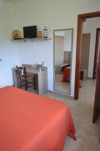 a room with a bed and a table with a mirror at Albergo Diana in Tronzano Lago Maggiore