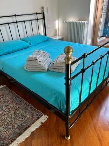 a bed with blue sheets and towels on it at Via Umbria 25 Luxury Suites in Rome