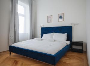 Brand Cozy Apartment في فيينا: سرير مع اللوح الأمامي الأزرق في الغرفة