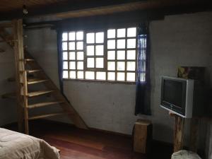a room with a staircase and a television and a window at CASA DE CAMPO in Riobamba
