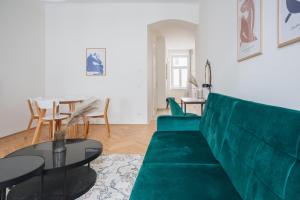 - un salon avec un canapé vert et une table dans l'établissement Brand Cozy Apartment, à Vienne