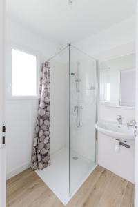 biała łazienka z prysznicem i umywalką w obiekcie TY PRAT - Jolie maison neuve proche mer w mieście Landunvez
