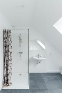 biała łazienka z umywalką i prysznicem w obiekcie TY PRAT - Jolie maison neuve proche mer w mieście Landunvez