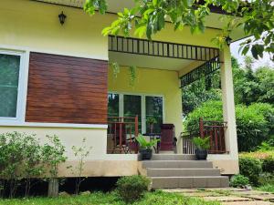 une maison jaune avec une terrasse couverte avec des escaliers et des plantes dans l'établissement Villa for rent, à Ko Chang