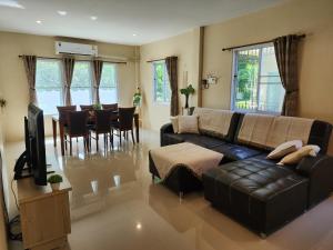een woonkamer met een bank en een eetkamer bij Villa for rent in Ko Chang