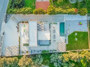 una vista aérea de una casa con patio en Chris and Stratos villa with private ecologic pool and kid's playground!, en Mourniaí