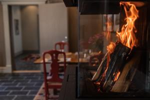 einen Kamin in einem Zimmer mit einem Tisch in der Unterkunft Marstrands Kurhotell in Marstrand