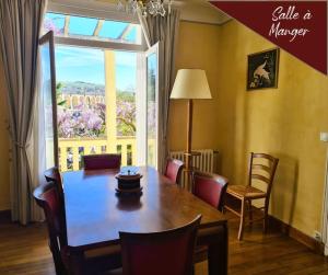 jadalnia ze stołem i krzesłami oraz oknem w obiekcie VILLA ANNEE 30 Rénovée ,Terrasse et Jardin w mieście Souillac