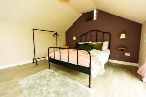 a bedroom with a bed with a black frame at Stay Barrow Blueway - The Stables in Monasterevin