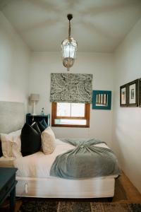 a bedroom with a bed and a chandelier at Thyme Out Weltevreden Farm in Curryʼs Post