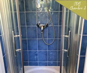 a shower with a hose in a blue tiled bathroom at VILLA ANNEE 30 Rénovée ,Terrasse et Jardin in Souillac